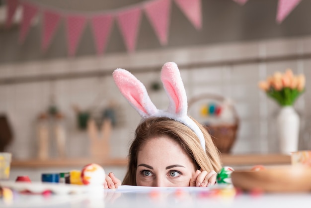 Bonita mãe com orelhas de coelho se escondendo