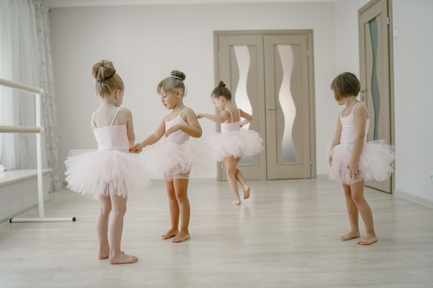 Foto grátis bonitinhas bailarinas em traje de balé rosa. crianças em sapatilhas de ponta dançam na sala