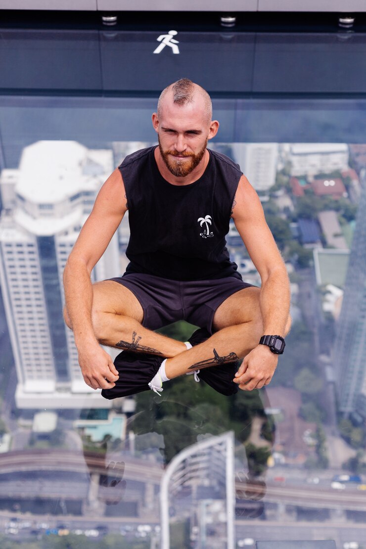Foto grátis bonito e brutal homem barbudo caucasiano no chão de vidro em bangkok
