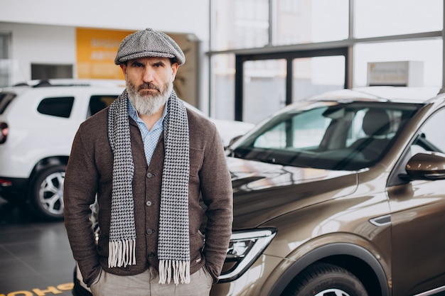 Bonito homem de negócios escolhendo um carro no showroom de carros