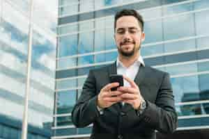 Foto grátis bonito, homem negócios, desfrutando, messaging texto, ligado, telefone móvel