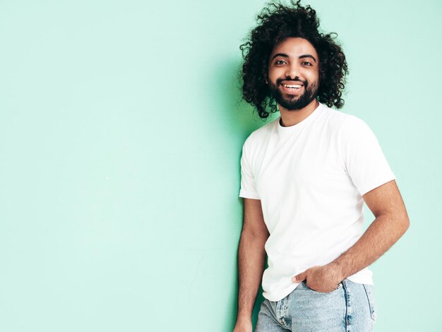 Bonito homem sorridente hipster posando no estúdio