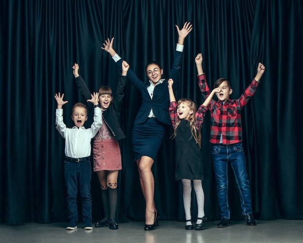 Bonitos crianças elegantes no estúdio escuro. As lindas meninas adolescentes e menino juntos