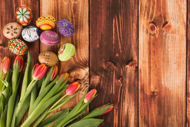 Bonitos ovos de Páscoa perto de tulipas