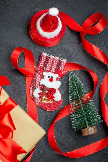 Bonitos presentes de natal meia árvore de natal chapéu de papai noel em fundo escuro