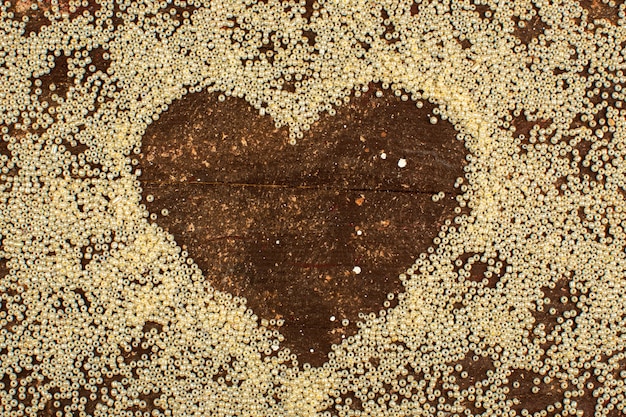 Foto grátis botões amarelos em torno da forma do coração em um piso marrom rústico de madeira