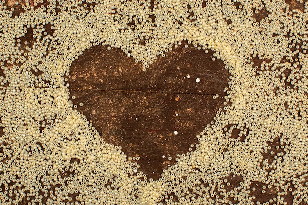 Botões amarelos em torno da forma do coração em um piso marrom rústico de madeira