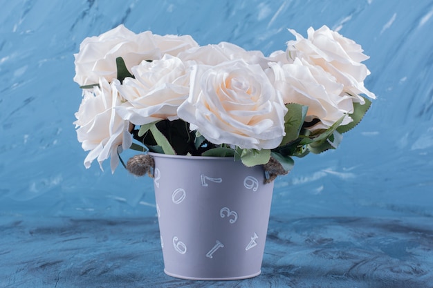 Bouquet de muitas rosas brancas colocadas em azul.