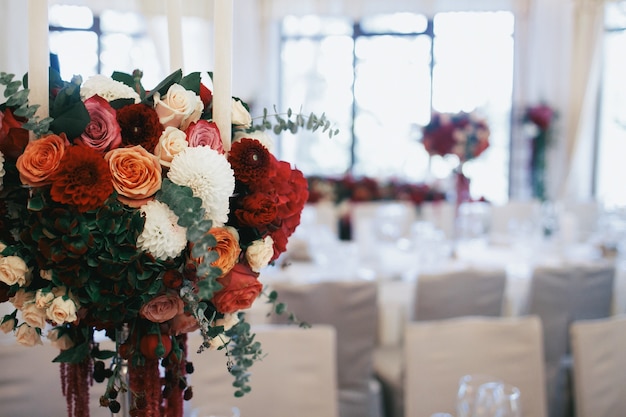 Bouquet de rosas e alfinete fica na mesa do jantar no restaurante