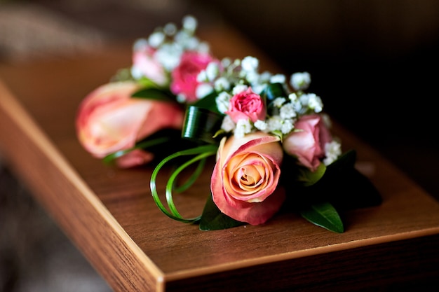 Foto grátis boutonnieres feitos de rosas e vegetação rosa estão de pé na mesa