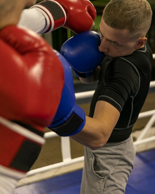 Boxeador praticando no ringue com treinador