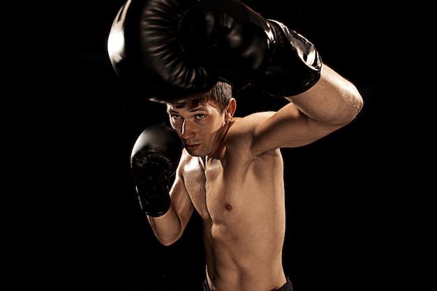 Boxer masculino boxe em saco de pancadas em preto