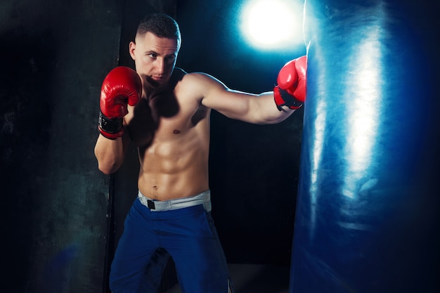 Foto grátis boxer masculino boxe em saco de pancadas