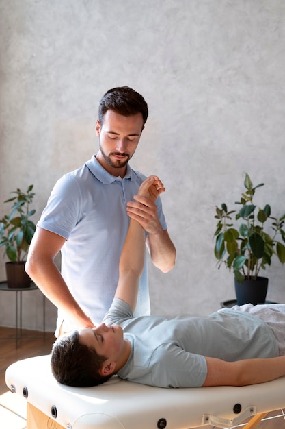 Foto grátis braço de verificação do fisioterapeuta de tiro médio