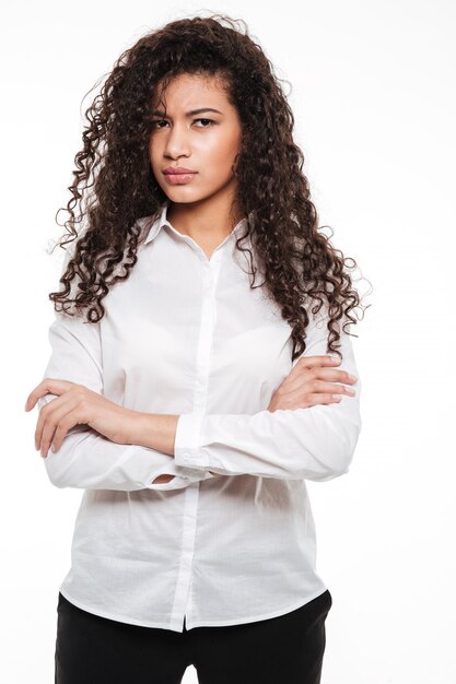 Foto grátis brava jovem africana encaracolada posando sobre fundo branco.