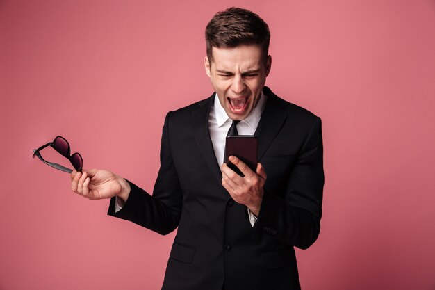 Bravo gritando descontente jovem empresário falando por telefone