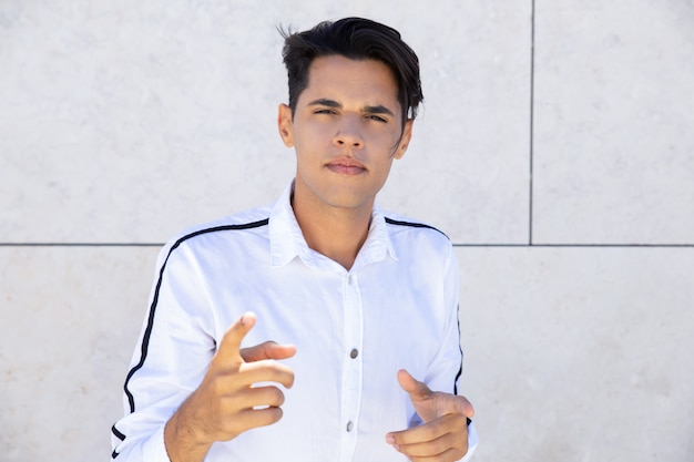 Foto grátis bravo jovem apontando para a câmera