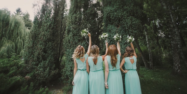 Bridemaids com bouquets altas