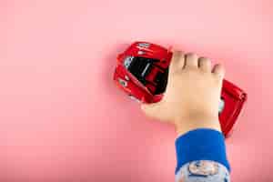 Foto grátis brinquedo pequeno carro vermelho para uma criança, uma criança brincando com ele