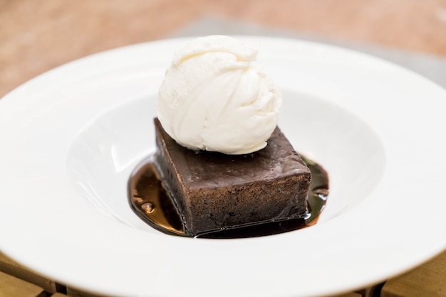 Brownie sundae com uma colher de sorvete de baunilha