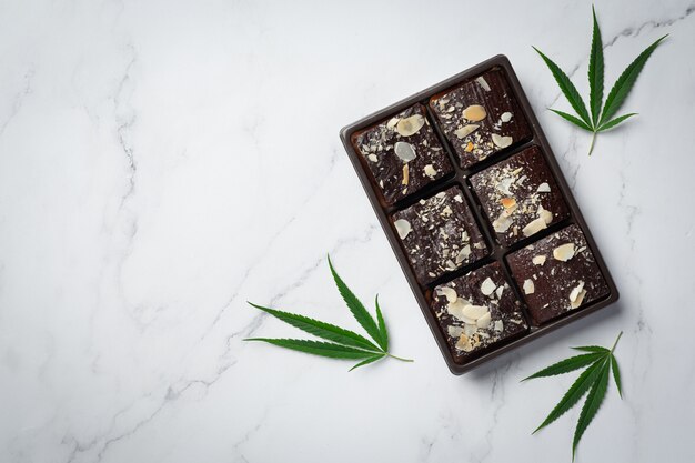 Brownies de cannabis e folhas de cannabis colocados no chão branco