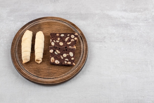 Foto grátis brownies de chocolate caseiros e biscoito de rolo em uma placa, sobre a mesa de mármore