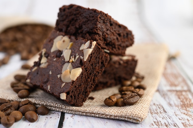 Brownies de chocolate de saco e grãos de café em uma mesa de madeira.