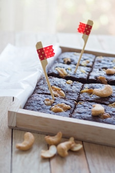 Brownies de chocolate decorados com nozes em caixa de madeira