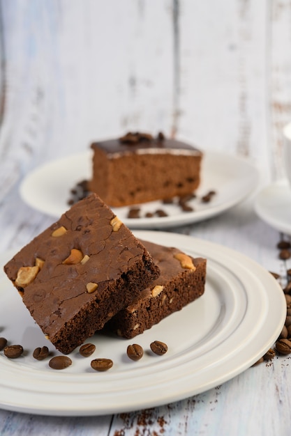 Foto grátis brownies de chocolate em um prato branco e grãos de café.