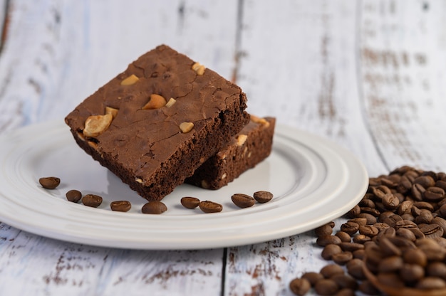 Brownies de chocolate em um prato branco e grãos de café.