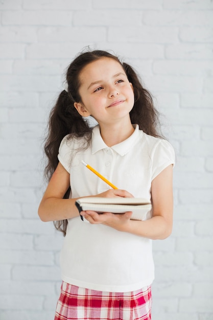 Foto grátis brunette, menina, segurando, caderno, pena, olhar, afastado