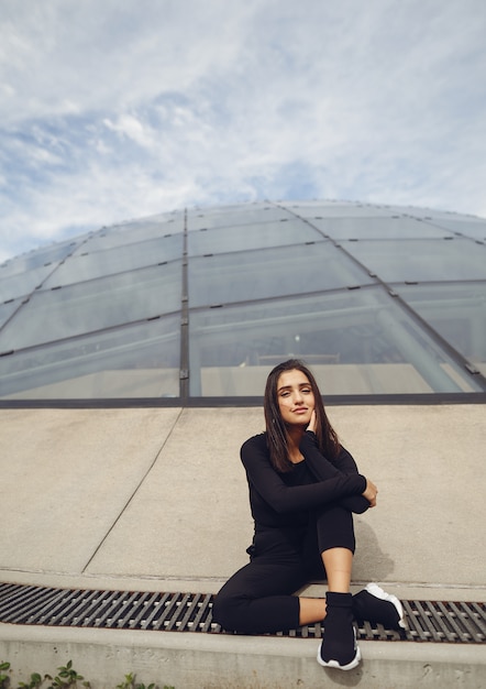 Brunetter garota ao lado de um edifício moderno