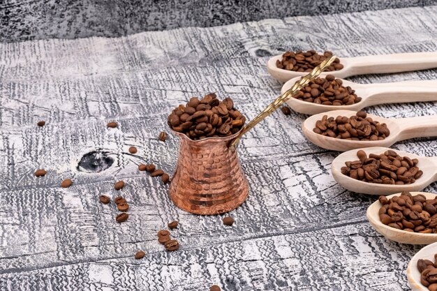 bule de café cheio de grãos de café na vista superior de madeira