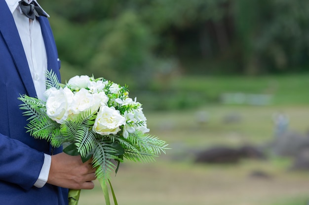 Buquê de casamento nas mãos do noivo.