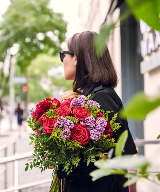 buquê de flores variuos nas mãos da menina