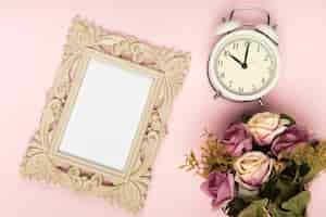 Foto grátis buquê de rosas ao lado do relógio e moldura