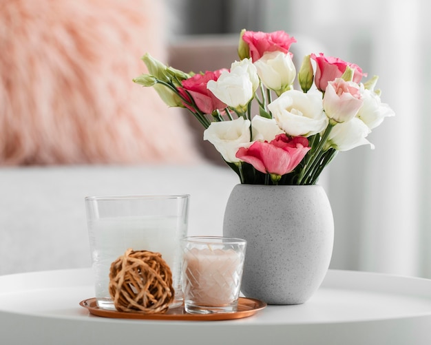 Buquê de rosas em um vaso próximo a objetos decorativos