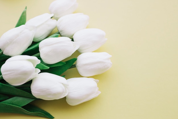 Foto grátis buquê de tulipas brancas em fundo amarelo