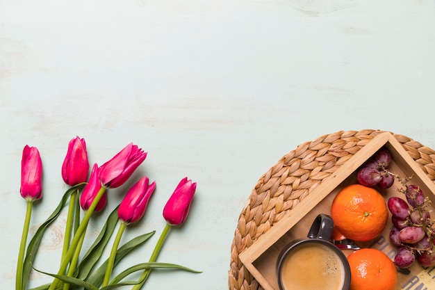 Foto grátis buquê de tulipas e bandeja com frutas