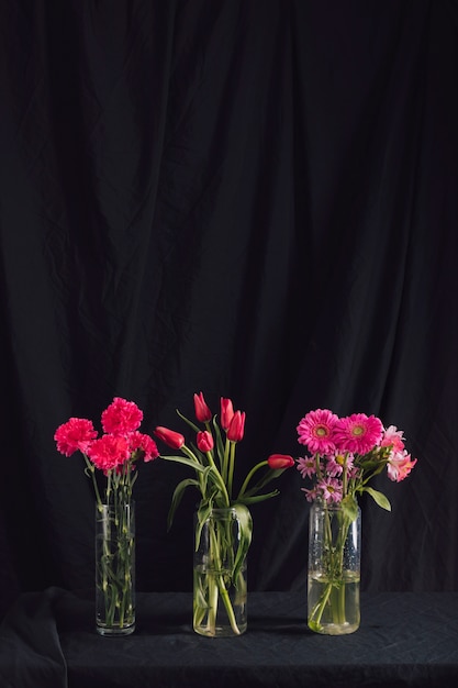Buquês de flores rosa em vasos com água