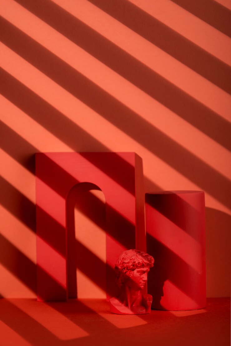 Foto grátis busto de gesso em fundo coral com formas geométricas