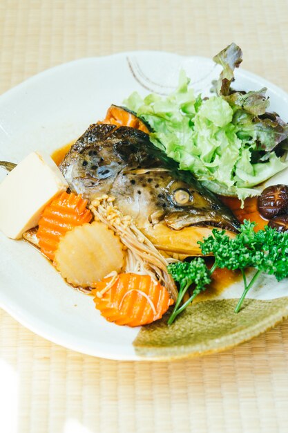 Cabeça cozida de peixe salmão com molho doce e vegetal