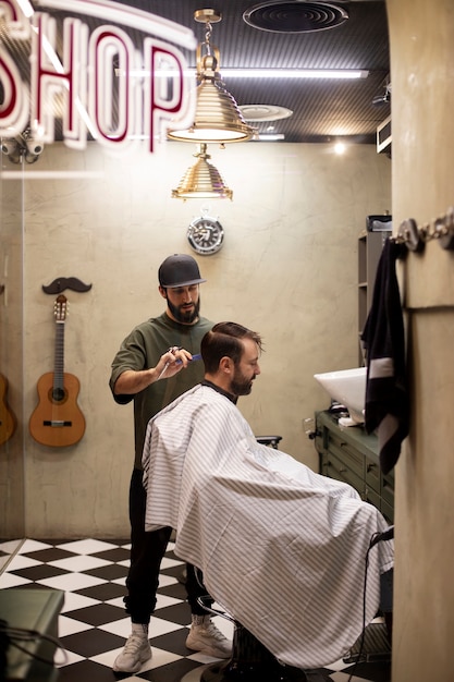 Cabeleireiro cortando cabelo de homem na barbearia