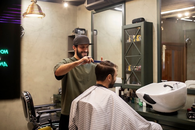 Cabeleireiro cortando cabelo de homem na barbearia