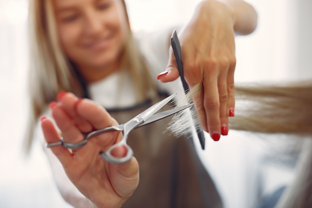 Cabeleireiro cortar o cabelo de seu cliente em um salão de cabeleireiro