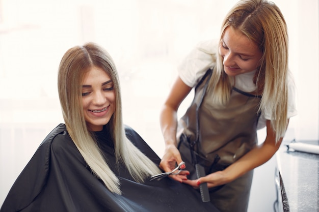 Cabeleireiro cortar o cabelo de seu cliente em um salão de cabeleireiro