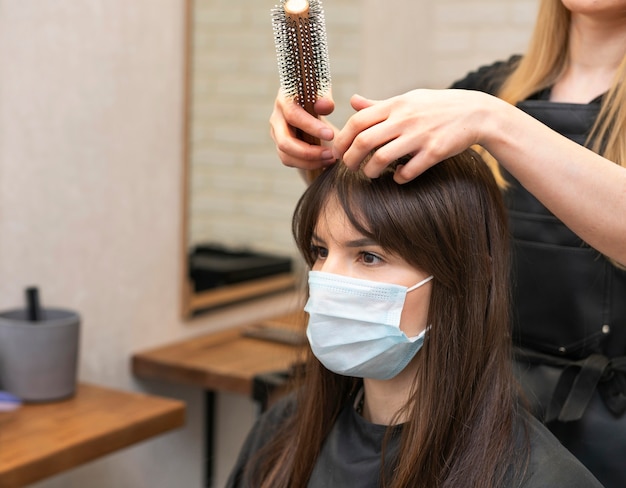 Cabeleireiro estilizando o cabelo de uma cliente