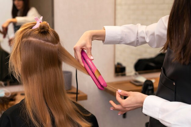 Cabeleireiro estilizando o cabelo de uma cliente