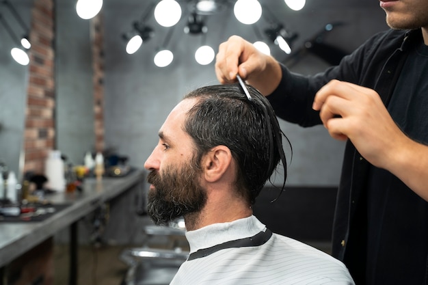 Cabeleireiro penteando o cabelo de perto