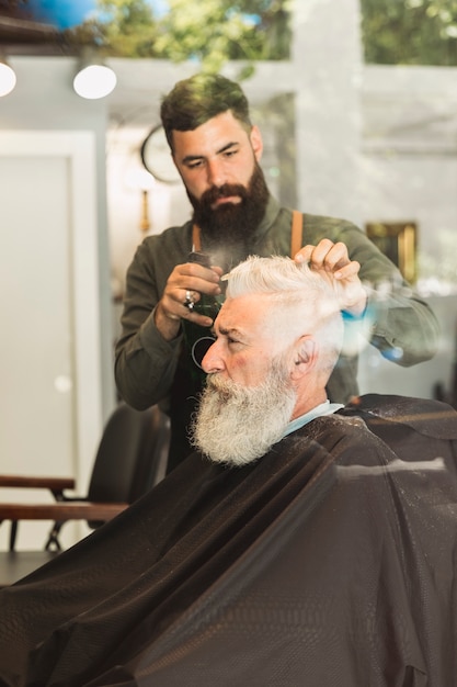 Cabelo de corte de cliente brutal velho na barbearia